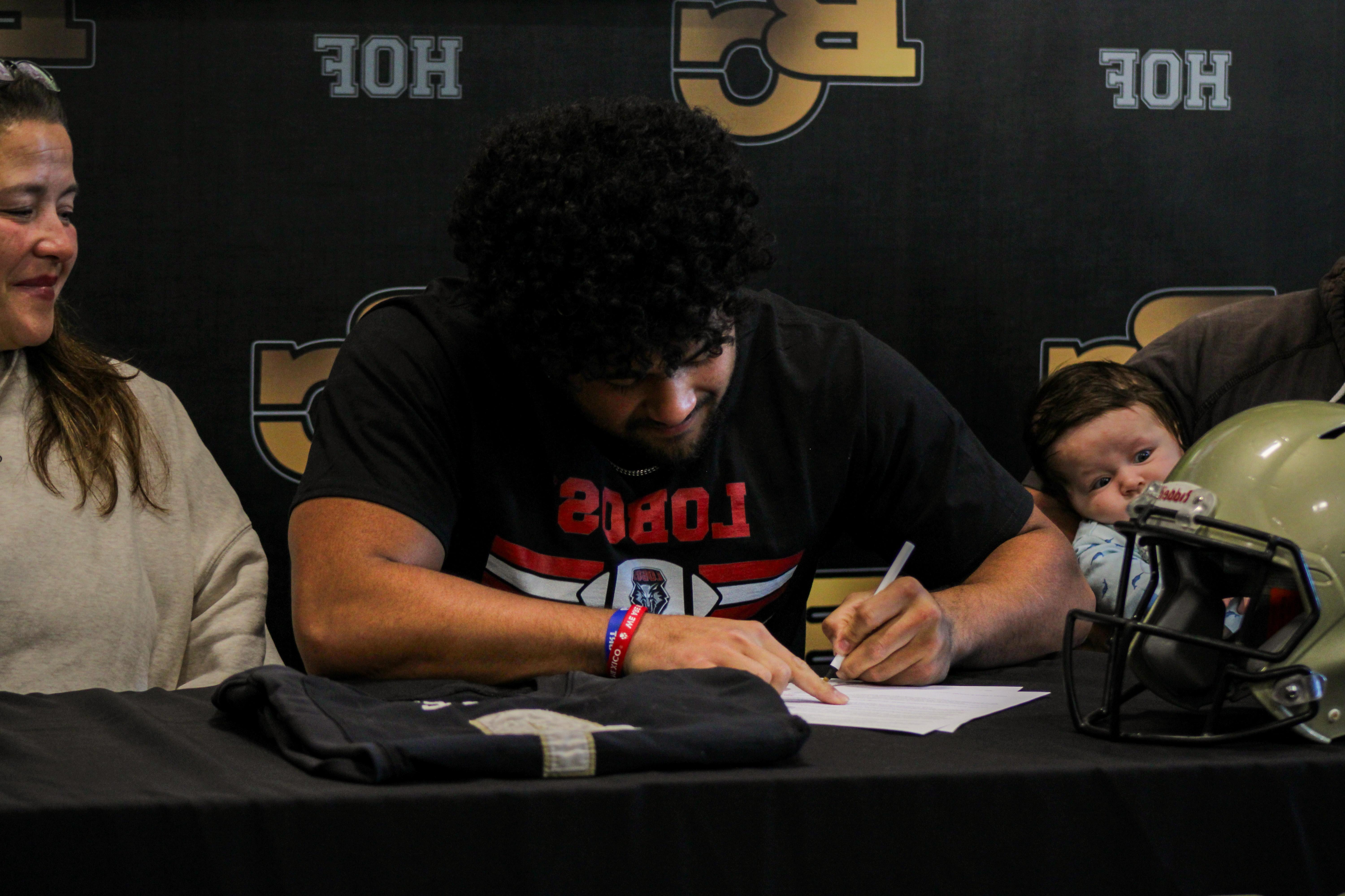 Takeshi Faupula signs his letter of inten.